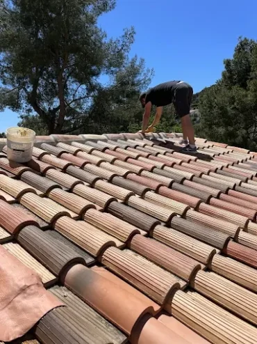 Artisan couvreur réalisant l'application d'un traitement hydrofuge imperméabilisant sur une toiture à Toulon dans le Var