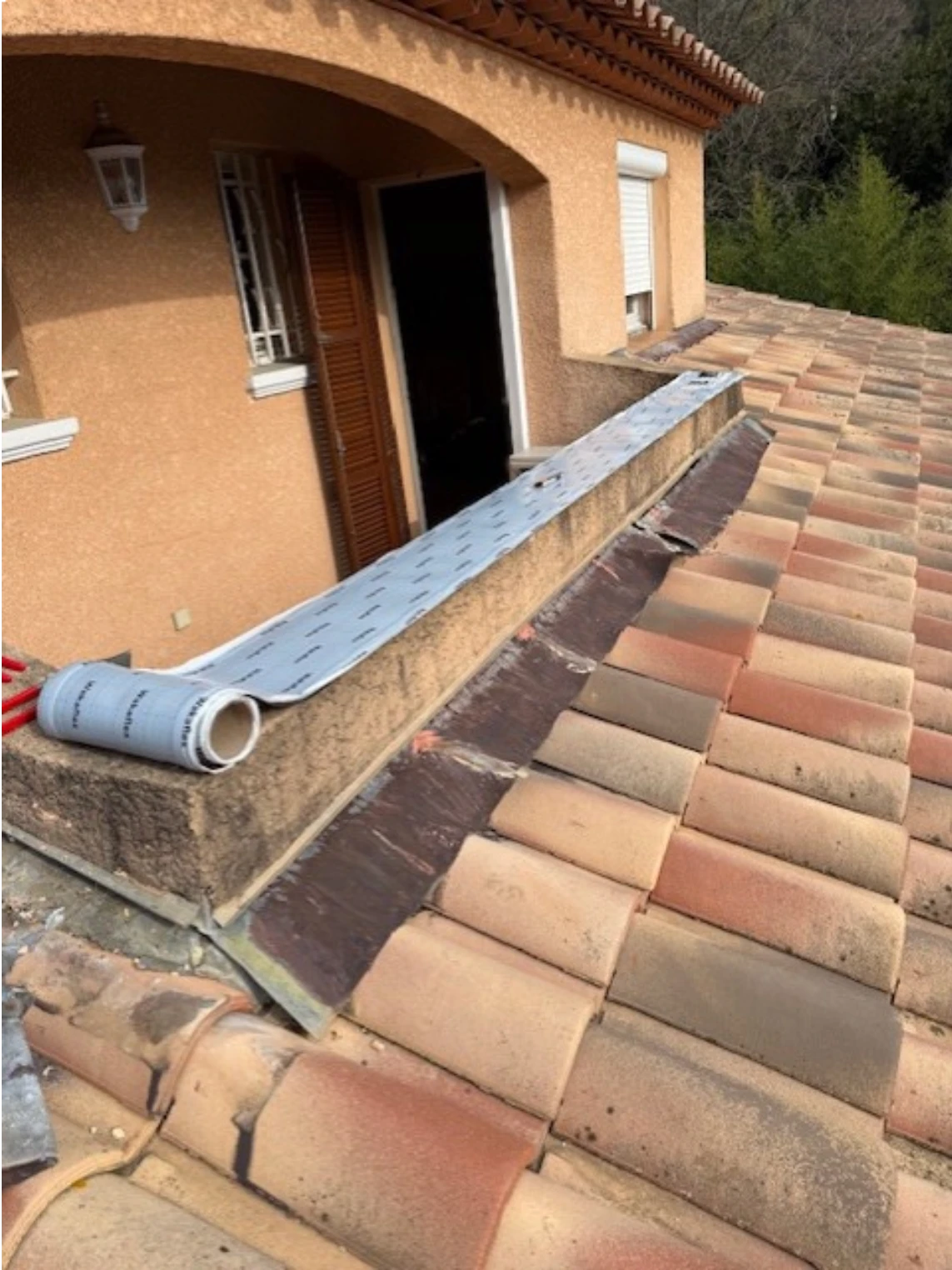 Artisan couvreur en train de découper et préparer un solin sur-mesure pour la toiture