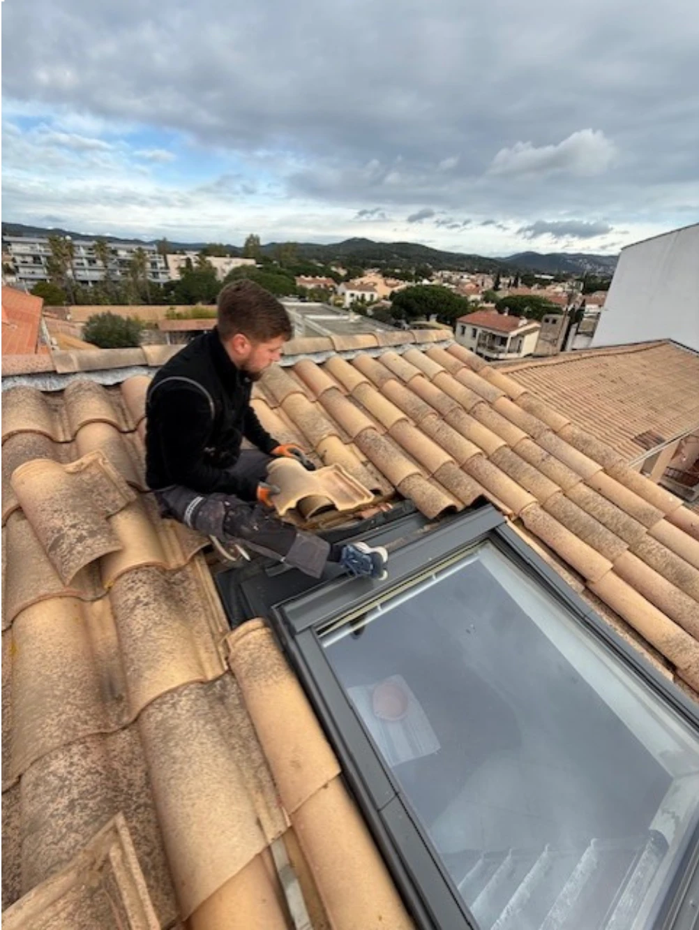 Repose des tuiles découpées autour du cadre du Velux